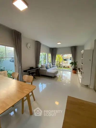 Spacious living room with modern decor and garden view, perfect for family gatherings.