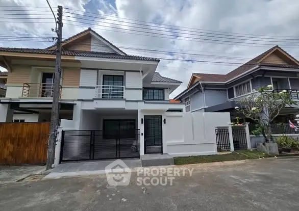 Modern two-story house with gated entrance and contemporary design.