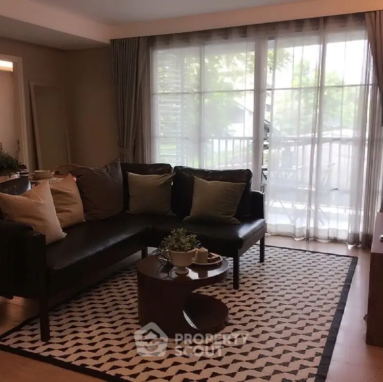 Stylish living room with modern decor and large window overlooking balcony.