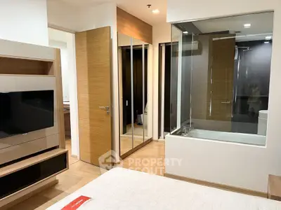 Modern bedroom with glass-enclosed bathtub and sleek wooden finishes