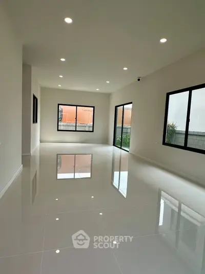 Spacious modern living room with glossy tiled floors and large windows for natural light.