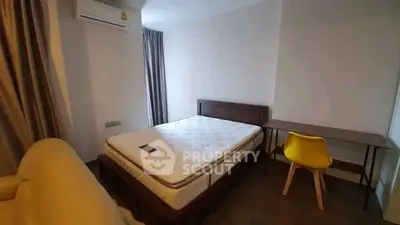 Cozy bedroom with modern furnishings, featuring a comfortable bed, stylish desk, and air conditioning.