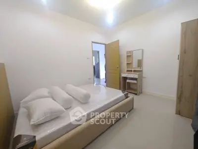 Spacious bedroom with modern furniture and natural lighting, perfect for relaxation and comfort.
