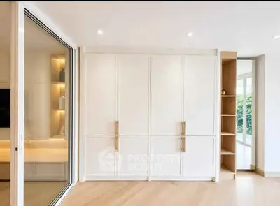 Spacious modern living room with large windows and built-in storage
