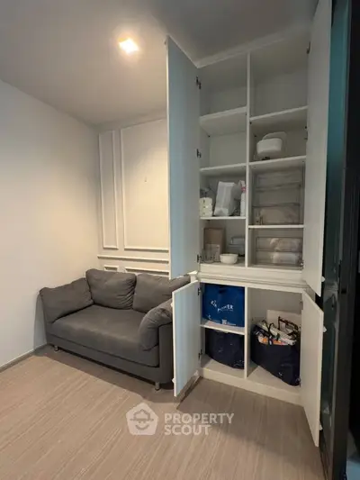 Cozy living room with stylish storage cabinet and comfortable gray sofa, perfect for modern living.