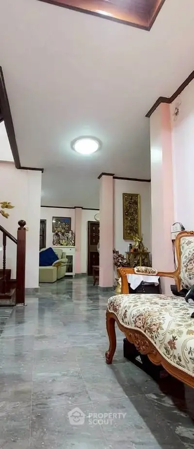Elegant living room with classic furniture and marble flooring in a spacious home.