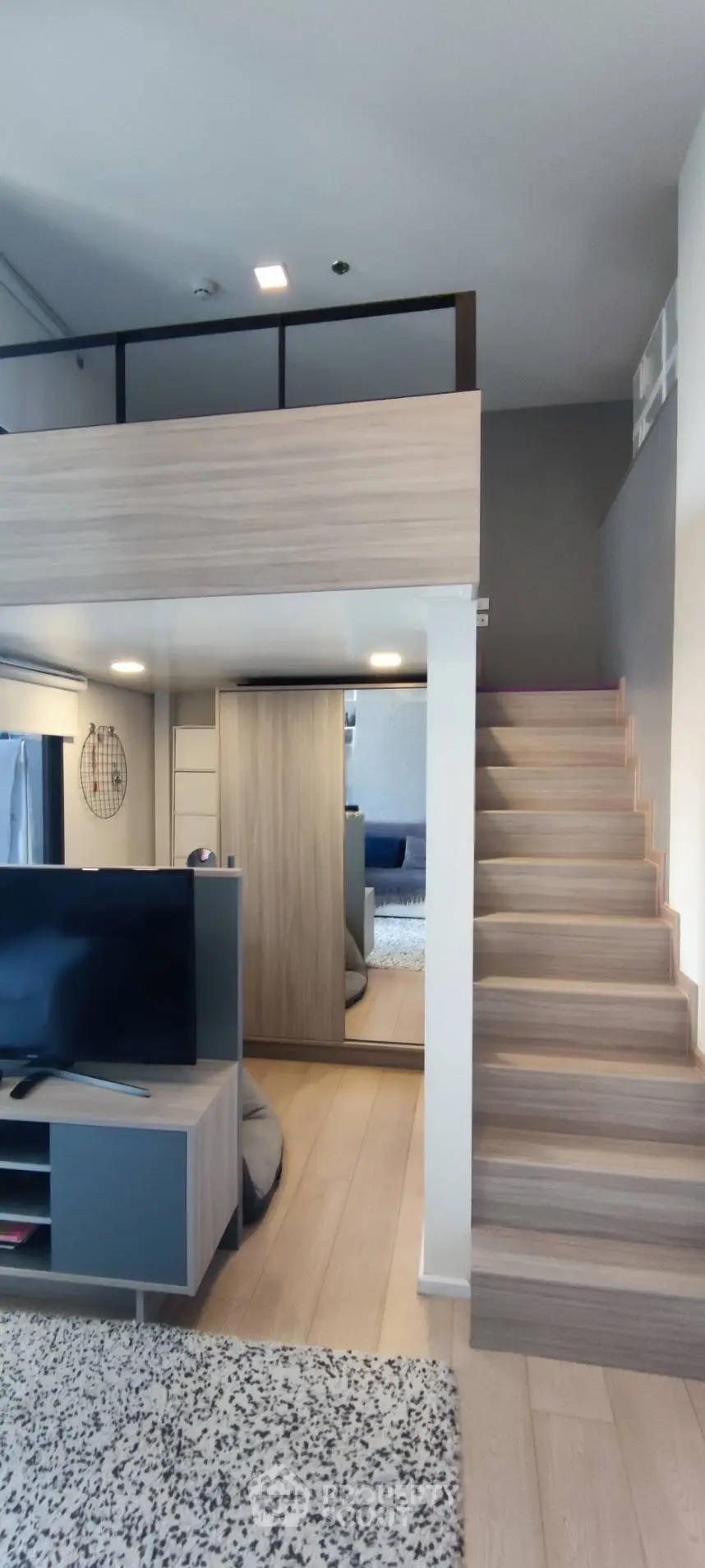 Modern loft apartment with stylish wooden staircase and open living area, perfect for urban living.