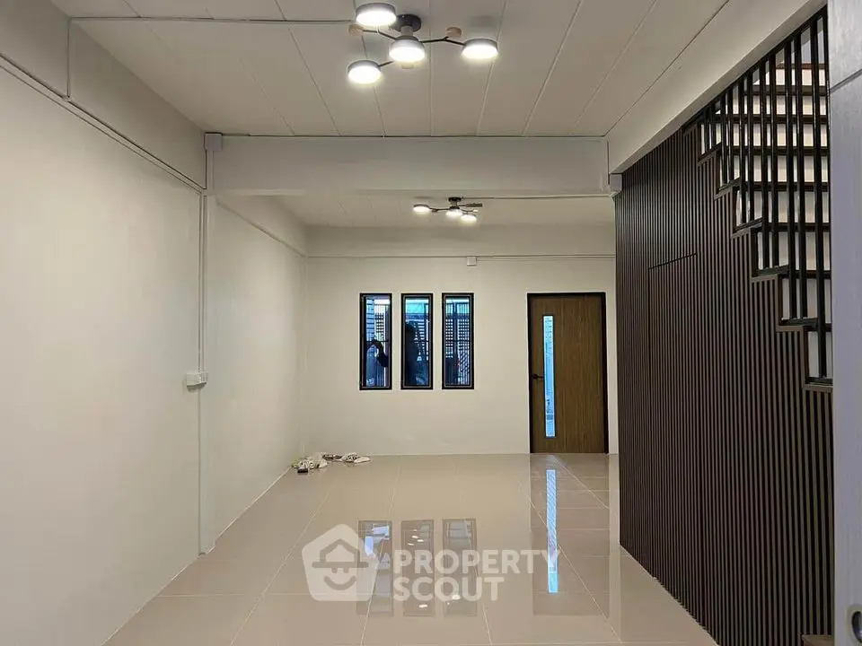 Spacious modern living room with sleek lighting and tiled flooring