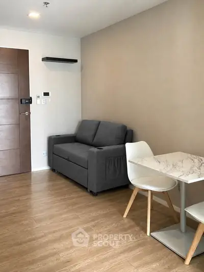 Modern living room with cozy gray sofa and stylish dining area in a contemporary apartment.