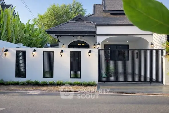 Charming modern house exterior with sleek black gate and lush greenery