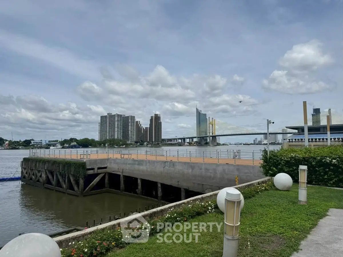 Scenic riverside view with modern buildings and bridge, perfect for urban living enthusiasts.