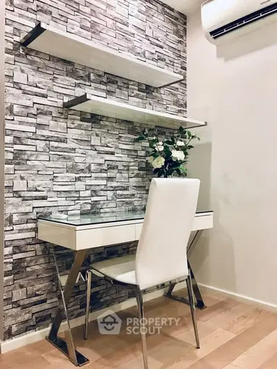 Modern study nook with sleek desk and chair, accented by stone wall and floating shelves.