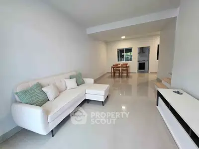 Spacious modern living room with sleek white sofa and open dining area