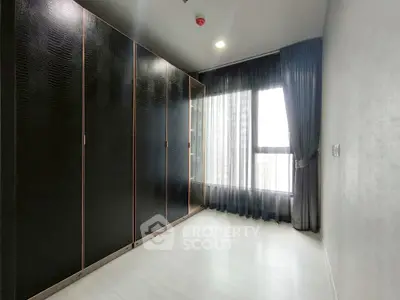 Spacious bedroom with large wardrobe and floor-to-ceiling window