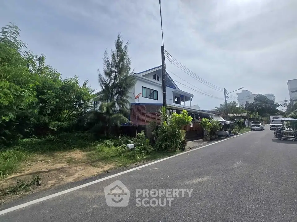 Charming suburban house with lush greenery and spacious surroundings on a sunny day.