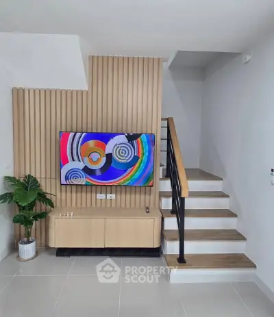Modern living room with stylish staircase and vibrant wall art