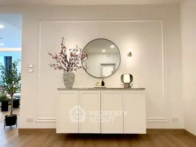 Elegant interior with stylish console table and round mirror in modern living space.