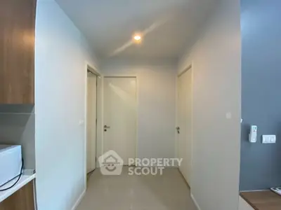 Modern hallway with sleek design and neutral tones, featuring a microwave and minimalist decor.