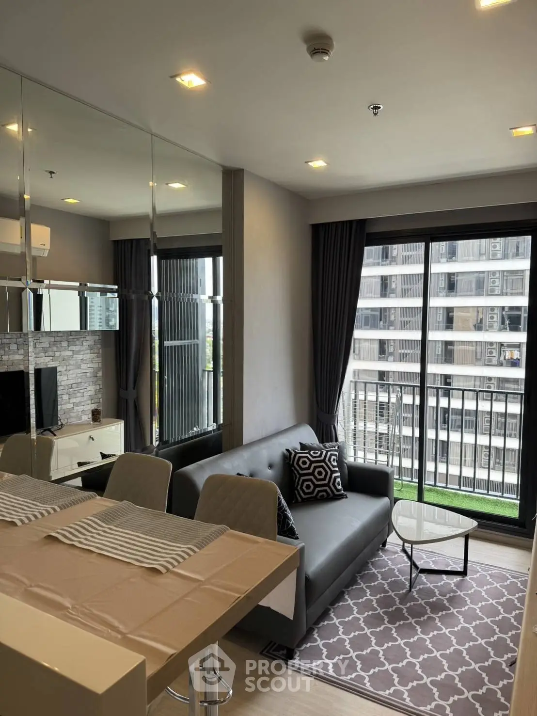 Modern living room with stylish decor and balcony view in a high-rise apartment.