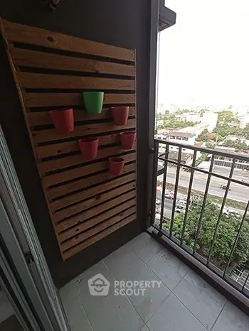 Charming balcony with wooden planter and city view, perfect for urban gardening enthusiasts.