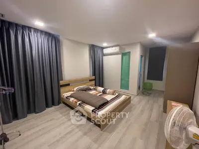 Spacious modern bedroom with stylish decor and ample natural light