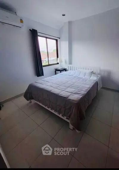 Cozy bedroom with large window and air conditioning in modern apartment