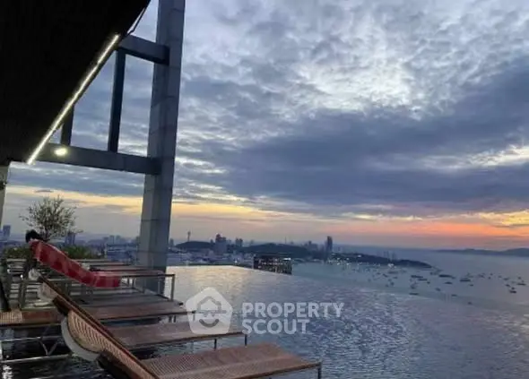 Stunning rooftop infinity pool with breathtaking city and ocean views at sunset.