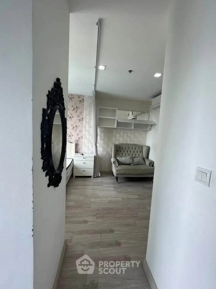 Charming interior hallway leading to a cozy living area with elegant decor and floral wallpaper.