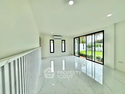 Spacious modern living room with large windows and garden view, featuring sleek white interiors and glossy flooring.