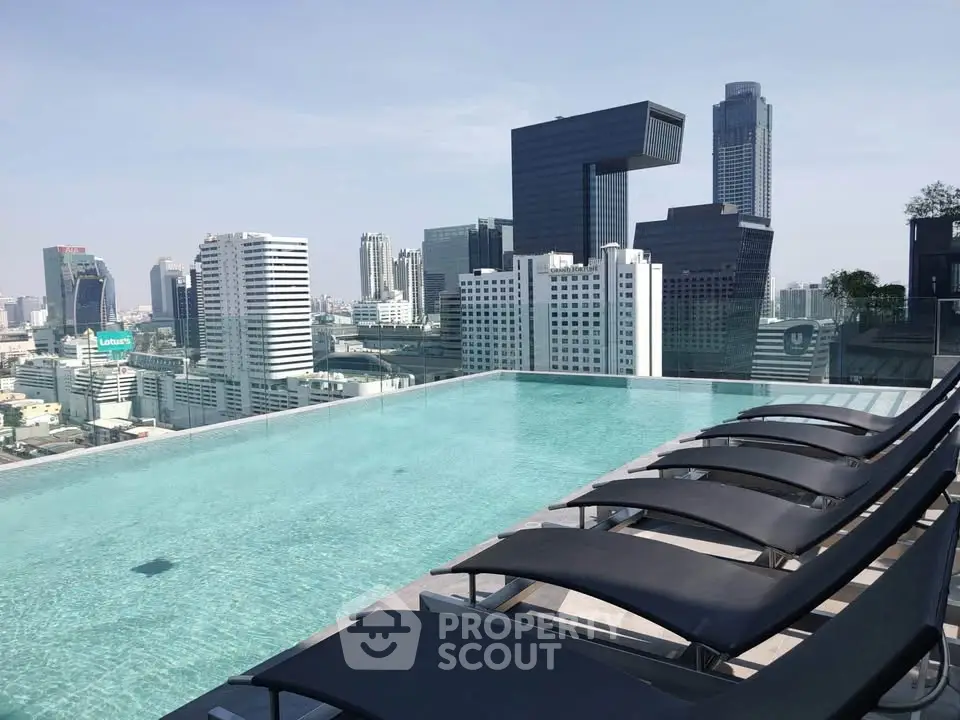 Luxurious rooftop pool with stunning city skyline views in a modern high-rise building.