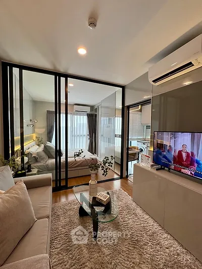 Modern living room with glass partition and cozy bedroom view