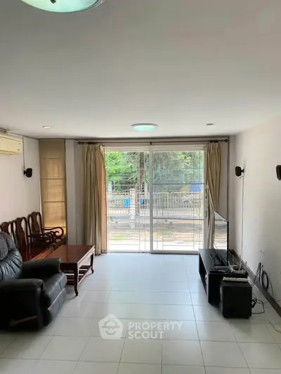 Spacious living room with modern furniture and large windows offering a bright and airy atmosphere.