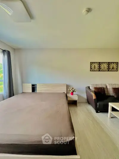 Spacious bedroom with modern decor and cozy seating area, perfect for relaxation.