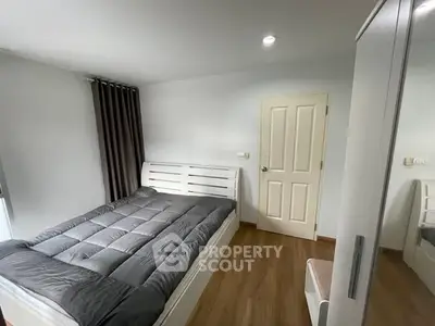 Cozy bedroom with modern decor and wooden flooring, perfect for relaxation.