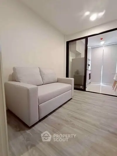 Modern living room with cozy sofa and sleek flooring in a stylish apartment.