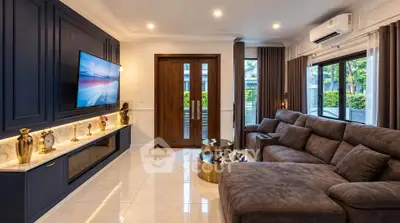 Luxurious living room with plush seating and modern decor, featuring large windows and elegant lighting.