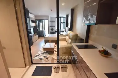 Modern open-layout living room and kitchen with stylish decor and ample natural light.