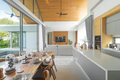 Luxurious open-plan living room with modern kitchen and dining area, featuring high ceilings and elegant decor.