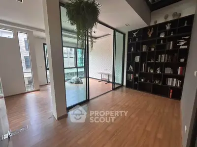 Spacious modern living room with wooden flooring and glass partition