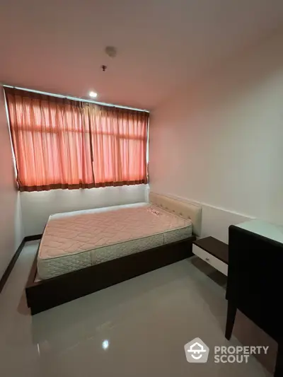 Cozy bedroom with a large window draped in coral curtains, featuring a queen-sized bed and sleek side furniture, perfect for restful nights.