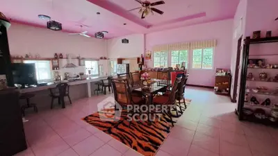 Spacious dining area with pink ceiling and large windows in a cozy home setting.