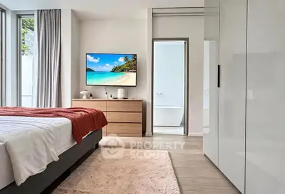 Modern bedroom with sleek design, featuring a large window, flat-screen TV, and elegant decor.