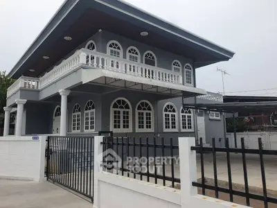 Elegant two-story house with arched windows and spacious driveway