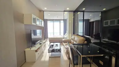 Modern living room with glass wall, leather sofa, and dining area in a stylish apartment.