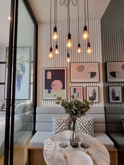 Stylish dining area with modern lighting and art decor in a contemporary apartment.