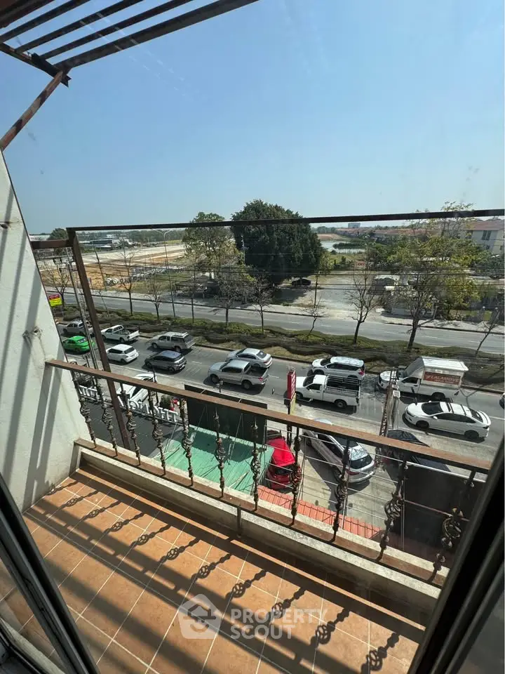 Charming balcony view overlooking a bustling street with scenic surroundings, perfect for urban living.