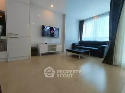 Modern living room with sleek furniture and large windows for natural light.