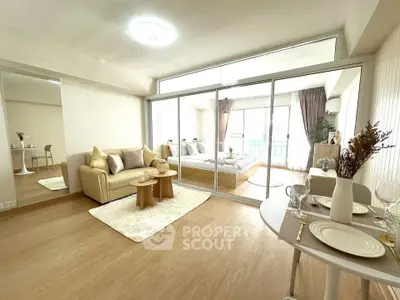 Spacious open-plan living room with cozy decor and large windows for natural light.