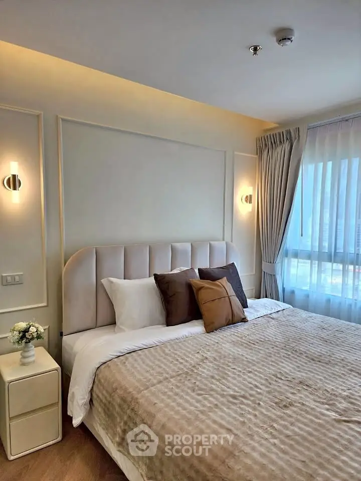 Luxurious bedroom with elegant decor and large window offering natural light