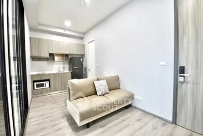 Modern open-layout living room with compact kitchen and sleek design